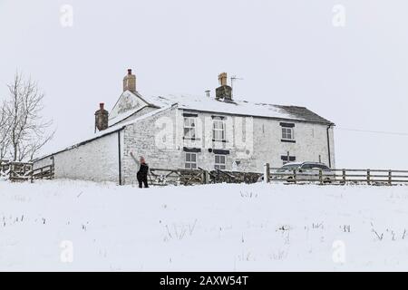 Upper Teesdale, County Durham, Großbritannien. Februar 2020. Wetter in Großbritannien. Eine Person hat die unbeneidenswerte Aufgabe einer langen Grabung, um den Weg zu ihrem Haus zu räumen, damit sie ihr Autokredit ausziehen: David Forster/Alamy Live News Stockfoto