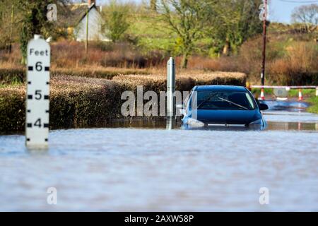 In der Nähe von Peasmarsh, Somerset, ist ein Auto im Hochwasserwasser stecken geblieben, wo über Nacht starke Regenfälle den nahe gelegenen Fluss Yarty zum Aufstieg geführt haben. Stockfoto