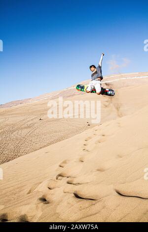 Sandboarding in Cerro Dragon, in der Atacama-Wüste. Iquique, Tarapaca Region, Chile. Stockfoto