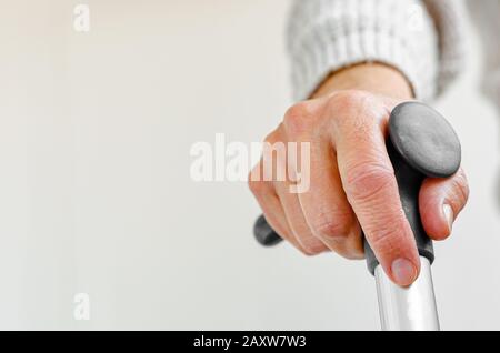 Rentnerin hält Metall-Gehstock in der Hand. Medizinisches und medizinisches Konzept. Kopierbereich Stockfoto