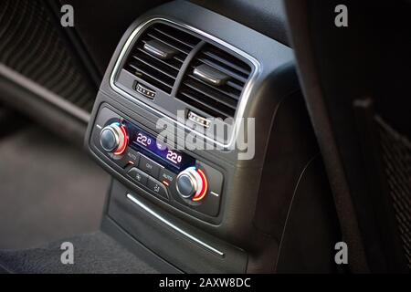 Bedienfeld mit digitalem Mehrfarbendisplay und Knöpfen für den Rücksitzpassagier in modernem Prestige Luxusauto-Interieur selektive Fokussierung mit Kopierspac Stockfoto