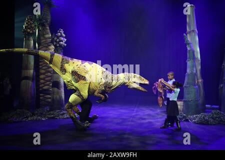 Kinder der Stockwell Primary School, London, treffen im Rahmen des "Imagine Children's Festival" des Southbank's Centre in London auf einen Puppentor aus Erths Dinosaur Zoo. Stockfoto