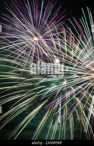 Das explodierende Feuerwerk-Display erzeugt einen bunten Kontrast von Farbe und verschwommener Bewegung gegen einen verdunkelten Nachthimmel. Spektakulärer Anblick in Baltimore MD. Stockfoto