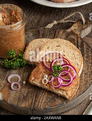 Schweineschmalz gemischt mit gemahlenen Knistern auf einer Scheibe Brot auf rustikalem Hintergrund Stockfoto