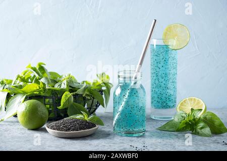 Blauer Cocktail mit Basiliensamen und tropischem Saft aus Glas auf hellem Hintergrund. Gesundes Entgiftungsgetränk für Gewichtsverlust. Stockfoto