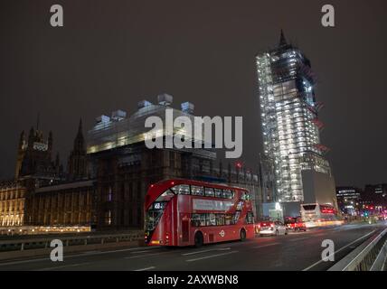 Der Verkehr, der über die Westminster Bridge führt, verlässt leichte Wege mit Big Ben und Einem Teil der Parlamentsgebäude, die mit Gerüsten bedeckt sind. Stockfoto