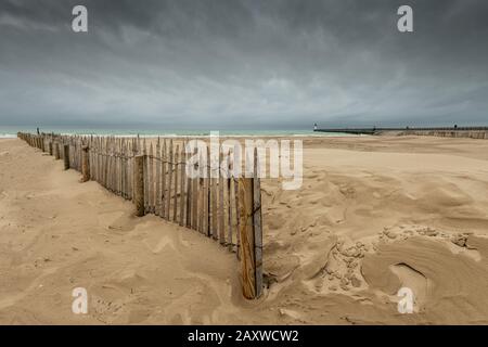 Ganivelle en chataigner pour fixer le sable, sur la plage de Calais, Frankreich, hiver Stockfoto