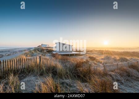 Cabines de plage dans les oyats givrés au lever du soleil, Frankreich, Hauts de France, hiver Stockfoto