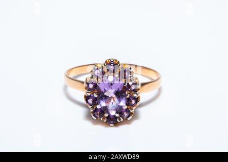 Schöner goldener Ring mit violettem Edelstein isoliert auf weißem Grund Stockfoto