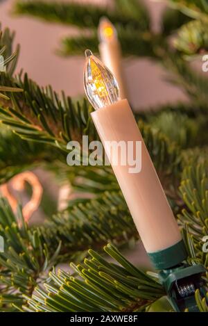Weiße Kerze an einem Weihnachtsbaum Stockfoto