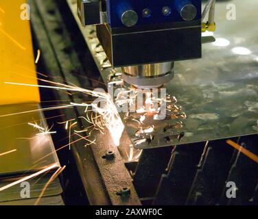 Faserlasermaschinen für die Nahaufnahme von Metall. Ein Laserstrahl schneidet das Blech in der Herstellung. Industrietechnologien, Produktionsprozesse Stockfoto