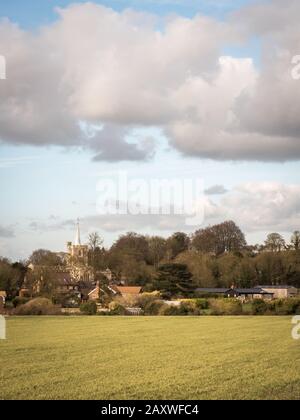 Ivinghae-Dorf, Buckinghamshire, England. Ein Blick auf das ländliche englische Dorf, das sich an einem sonnigen Wintertag gegen ein braches Fruchtfeld und einen bewölkten Himmel gerichtet hat. Stockfoto