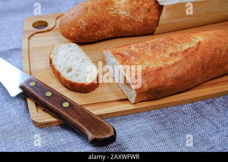 Frische warme Baguette mit knuspriger Kruste. Zum Frühstück in Scheiben geschnitten. Für das Morgen-Sandwich. Stockfoto