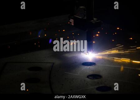 Plasmaschneiden von Metall mit einer cnc. Plasmaschneidmaschine zum Schneiden von Stahlblech. Laserschneider in Produktion. Industrielles Metallschneiden mit Plasmalaser. Funken fliegen vom Laser Stockfoto