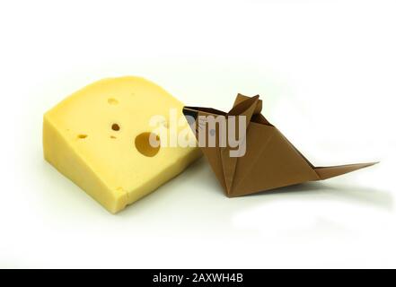 Braune Origami-Maus in der Nähe einer großen Scheibe Käse isoliert auf wihite Hintergrund. Kopierbereich. Stockfoto