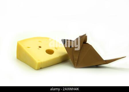 Braune Origami-Maus in der Nähe einer großen Scheibe Käse isoliert auf wihite Hintergrund. Kopierbereich. Stockfoto