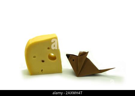 Braune Origami-Maus in der Nähe einer großen Scheibe Käse isoliert auf wihite Hintergrund. Kopierbereich. Stockfoto