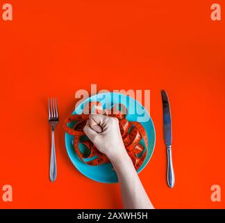 Draufsicht: Rotes Maßband auf der Platte. Diät-Konzept. Stockfoto