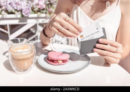 Frau nach dem Frühstück in einem Café zahlt mit Kreditkarte. Konzept der bargeldlosen Zahlungen und Rückvergütung in der Cafeteria Stockfoto