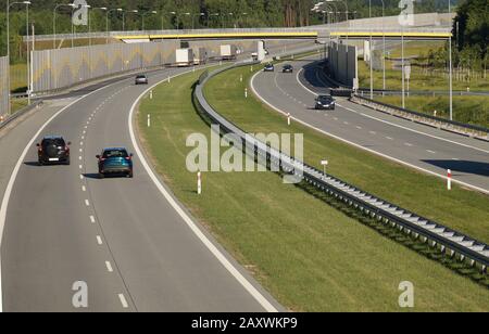 Lärmschutz. Autoverkehr auf einer sich schnell bewegenden Straße mit Schallschutzplatten. Stockfoto