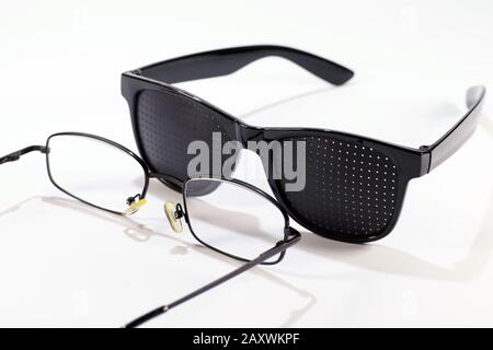 Zwei Brillenpaare. Lochbrille im Vergleich zu klassischen Brillen. Stockfoto