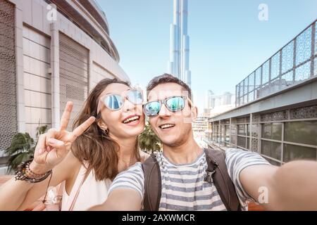 Zwei Freunde ein Mann und eine Frau reisen in Dubai und machen ein selfie-foto vor dem Hintergrund der Wolkenkratzer. Tourismus in den Vereinigten Arabischen Emiraten Stockfoto