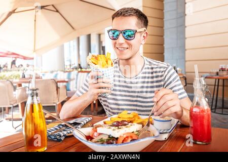 Fröhlicher Mann, der Gyros Pita im Café isst. Küche im mittleren Osten der Straße Stockfoto
