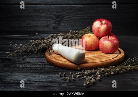 Stillleben, Äpfel auf schwarzem Grund umgeben von getrockneten Blumen Stockfoto