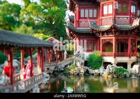 Ruhiger asiatischer Garten mit Teich bei Sonnenuntergang. Spezielle Linse für den selektiven Miniaturfokuseffekt. Stockfoto