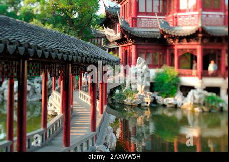 Traditioneller asiatischer Garten mit Teich bei Sonnenuntergang. Spezielle Linse für den selektiven Miniaturfokuseffekt. Stockfoto