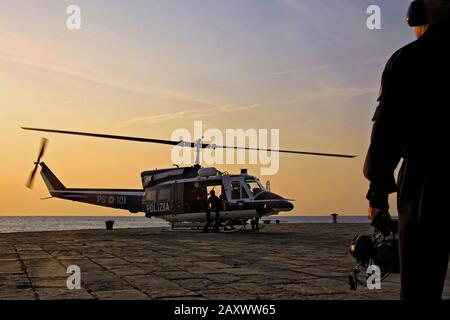 Triest, Italien - 27. September 2009: Italienischer Polizeihubschrauber beim Start vom Hafenkai bei Sonnenuntergang. Stockfoto