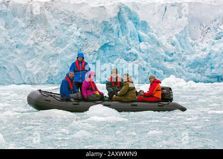 Ökotouristen mit Führer in aufblasbaren Boot- und Eiswänden des Wagonwaybreen-/Wagonway-Gletschers, des Magdalenefjordens, Spitzbergen/Spitzbergen, Norwegen Stockfoto