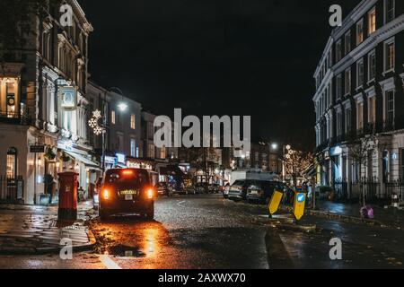 London, Großbritannien - 26. November 2019: Schwarzes Taxi auf einer Straße in Primrose Hill, einem gehobenen Gebiet von North London, das seinen Namen von der berühmten Primrose Hil erhielt Stockfoto