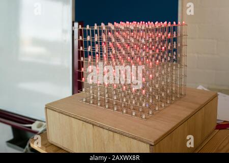 Würfel mit LED-Leuchten (Licht emittierende Diode) im Klassenraum. Der elektrische Schaltkreis schaltet die Beleuchtung ein und aus und ändert die Farben, was interessante Muster hervorruft. Stockfoto