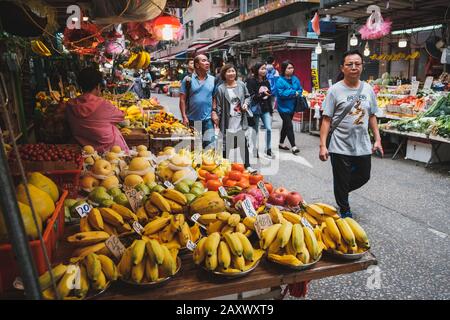 Hongkong - November 2019: Menschen kaufen Lebensmittel auf dem überfüllten Markt für Straßennahrungsmittel in Hongkong Stockfoto