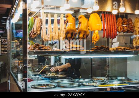 Hongkong - November 2019: Chinesischer Restaurantchef bereitet hinter dem Schaufenster Speisen zu Stockfoto