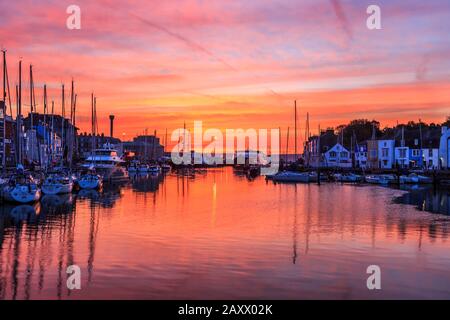 Sunrise Colors and Reflections, weymouth Old Harbor, Fischerboote, aufgeführte Riverside Buildings, River Wey, weymouth, dorset, england, Großbritannien Stockfoto