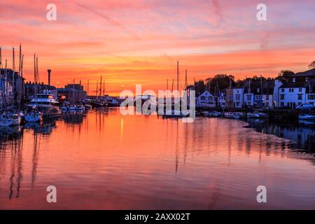 Sunrise Colors and Reflections, weymouth Old Harbor, Fischerboote, aufgeführte Riverside Buildings, River Wey, weymouth, dorset, england, Großbritannien Stockfoto