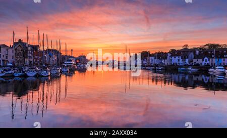 Sunrise Colors and Reflections, weymouth Old Harbor, Fischerboote, aufgeführte Riverside Buildings, River Wey, weymouth, dorset, england, Großbritannien Stockfoto