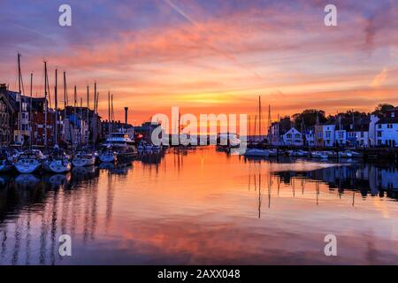 Sunrise Colors and Reflections, weymouth Old Harbor, Fischerboote, aufgeführte Riverside Buildings, River Wey, weymouth, dorset, england, Großbritannien Stockfoto