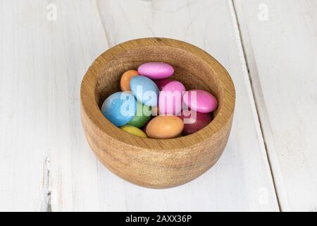 Viel süße bunte Süßigkeiten in Bambusschale auf weißem Holz Stockfoto