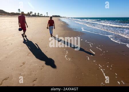 Ein Paar, die am Strand, Queens Beach, Queensland, Australien laufen Stockfoto