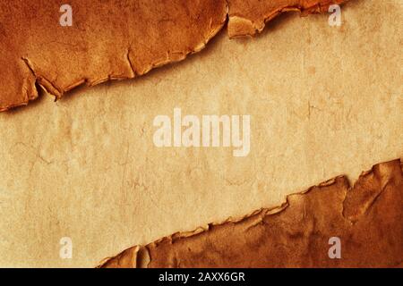 Draufsicht über zwei zerrissene alte alte, alte Papierstücke, diagonal auf Vintage-Blatt Papier mit Kopierraum. Stockfoto