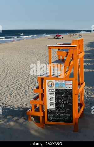 Outer Banks, NC, 4. Juni 2019, EIN heller, sonniger Frühabend an einem fast leeren Strand mit einem dominanten orangefarbenen Rettungsstand. Stockfoto