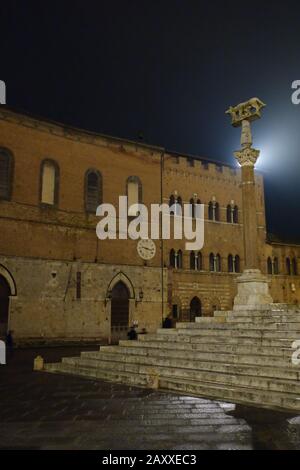 Siena bei Nacht. Piazza del Duomo. Das Symbol der Kapitolinischen Wolfstatue der Stadt mit Blick auf die Duomostufen. Stockfoto