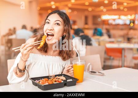 Glückliche Frau, die asiatische bento-mittagessen in Foodcourt isst Stockfoto