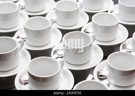 Viele leere weiße Teetassen abstrakte Hintergrundtextur in der Lebensmittelindustrie, repetitive Muster-Becher, die mit Löffeltapeten gestapelt sind Weiße Gerichte, Catering Stockfoto