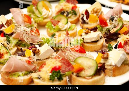 Einfach viele leckere kleine kleine Sandwiches, kleine Gourmet-Schmorgasbord-Nahaufnahme, Lebensmittel-Foto-Makro. Gesunde köstliche Leckereien auf Brot mit Käse Stockfoto