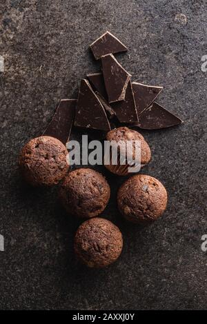 Schmackhafte Schokoladenmuffins. Süße Cupcakes und Schokolade auf dem alten Küchentisch. Draufsicht. Stockfoto