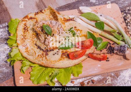 Shawarma in dünnem Kita-Brot mit Huhn und Gemüse auf einem Holztisch Stockfoto